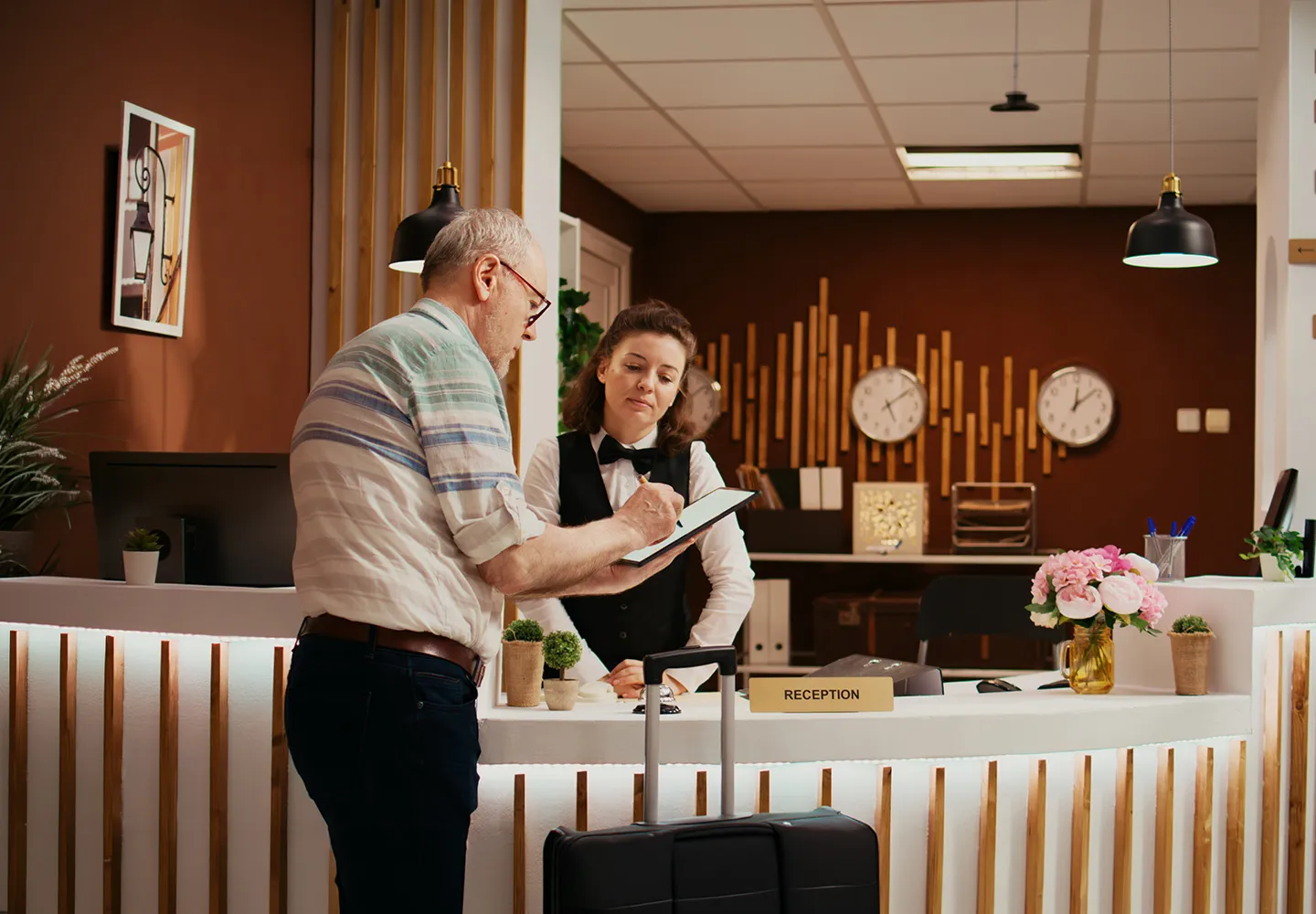 Guest checking in at a hotel reception desk with a receptionist